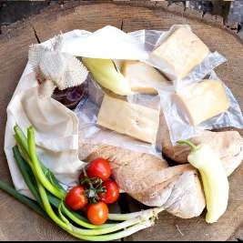 Bacon roast bundle in a canvas bag with bread, tomatoes, peppers and spring onions